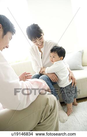 Picture - Family of three in living room. Fotosearch