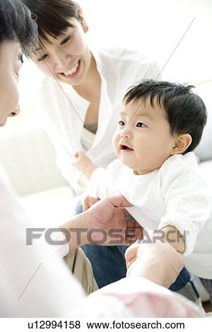 Stock Photo - Family of three in living room. Fotosearch