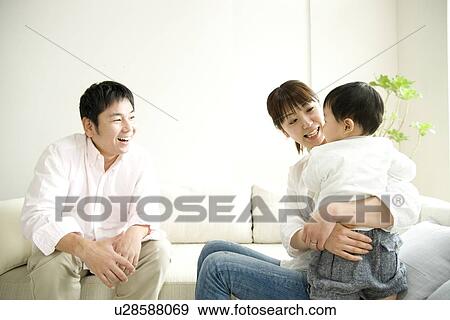 Stock Photo - Family of three in living room. Fotosearch