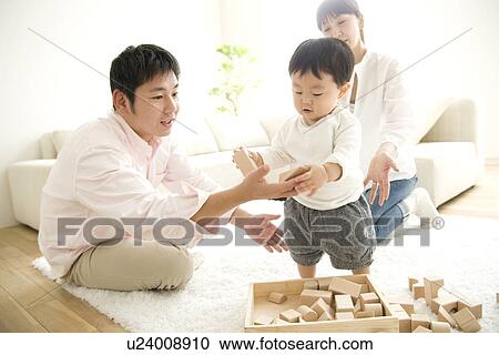Stock Image - Family playing in living room. Fotosearch