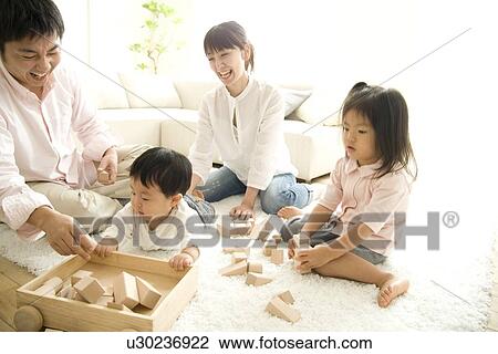 Stock Image - Family playing in living room. Fotosearch