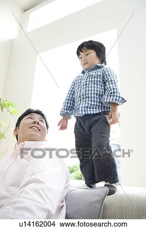 Father and son in living room View Large Photo Image Picture - Father and son in living room. Fotosearch