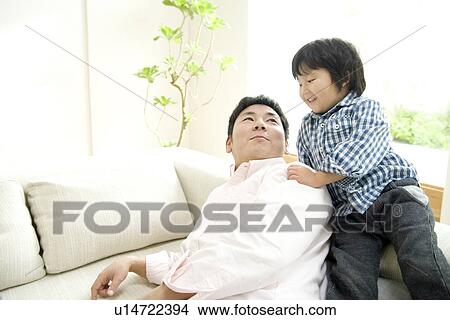 Picture - Father and son in living room. Fotosearch