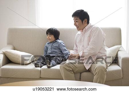 Father and son in living room View Large Photo Image Stock Image - Father and son in living room. Fotosearch