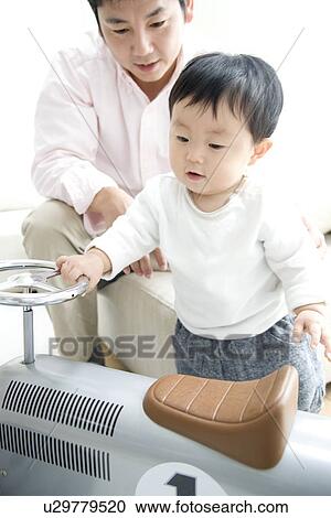 Father and son playing in living room View Large Photo Image Stock Image - Father and son playing in living room. Fotosearch