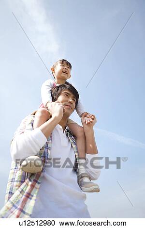 Stock Image - Father Carrying Daughter on Shoulders. Fotosearch