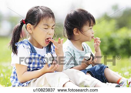 Girl and Boy Sitting on Grass and Eating Rice Ball View Large Photo Image Stock Photo - Girl and Boy Sitting on Grass and Eating Rice Ball. Fotosearch