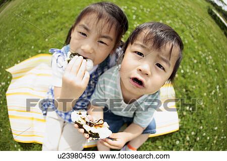 Girl and Boy Sitting on Grass and Eating Rice Ball View Large Photo Image Stock Photo - Girl and Boy Sitting on Grass and Eating Rice Ball. Fotosearch