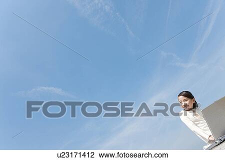 Stock Image - Girl Using Laptop on Beach. Fotosearch