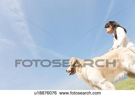 Stock Photograph - Girl With Dog Against Blue Sky. Fotosearch