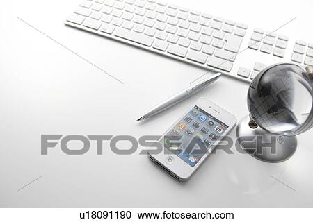 Stock Image - Globe, Smart Phone and Pen on Desk. Fotosearch