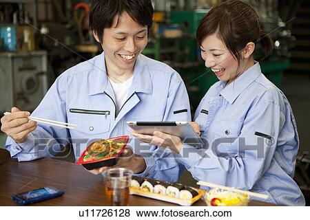Stock Photo - Male and Female Worker Having Lunch Break. Fotosearch
