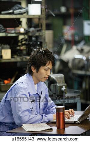 Stock Image - Male Factory Worker Using Laptop. Fotosearch