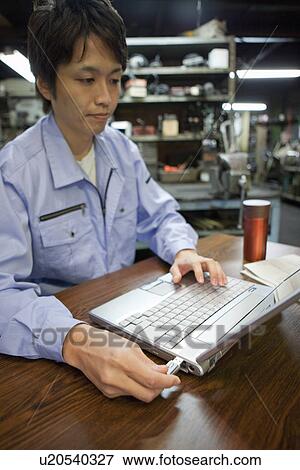 Stock Photo - Male Factory Worker Using Laptop. Fotosearch