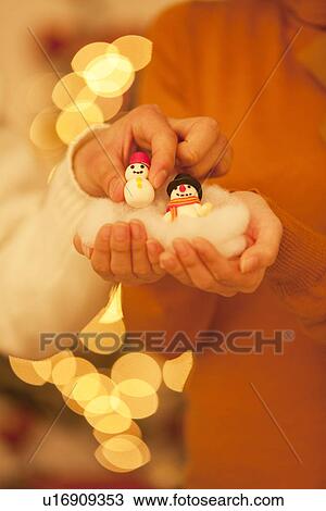 Stock Image - Man Taking Snowman From Woman'S Hands. Fotosearch