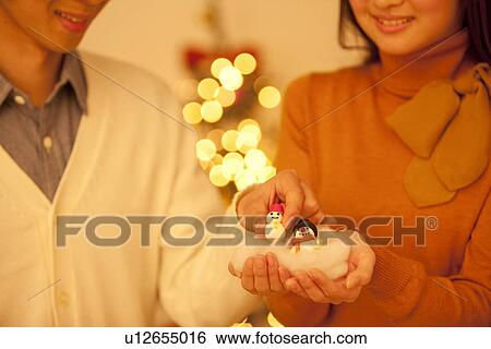 Stock Photograph - Man Taking Snowman From Woman'S Hands. Fotosearch