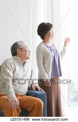Mature Couple Looking Through Window In Living Room View Large Photo Image Stock Photograph - Mature Couple Looking Through Window In Living Room. Fotosearch