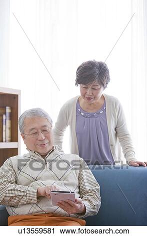 Mature Couple Using Digital Tablet In Living Room View Large Photo Image Stock Image - Mature Couple Using Digital Tablet In Living Room. Fotosearch