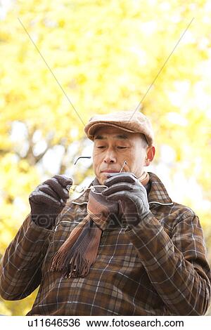 Mature Man Putting on Glasses In Autumn View Large Photo Image Stock Photograph - Mature Man Putting on Glasses In Autumn. Fotosearch