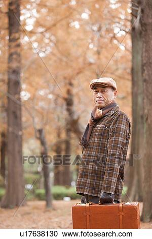 Stock Image - Mature Man Walking In the Woods In Autumn. Fotosearch