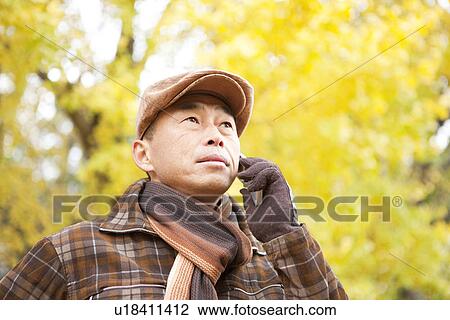 Stock Image - Mature Man Walking In the Woods In Autumn. Fotosearch