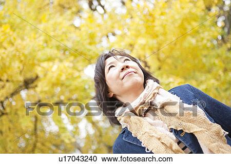 Stock Image - Mature Woman Walking In the Woods In Autumn. Fotosearch