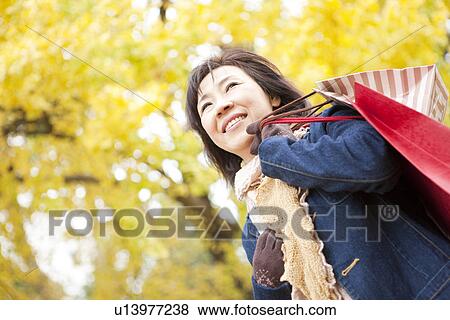Stock Photo - Mature Woman Walking In the Woods In Autumn. Fotosearch