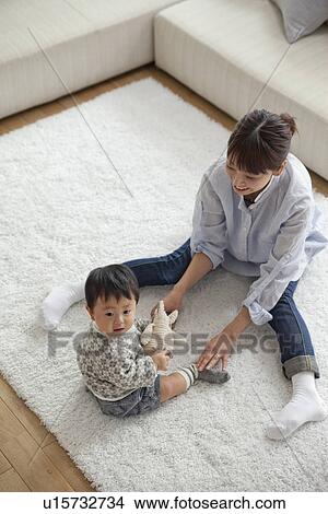Picture - Mother and baby boy playing in living room. Fotosearch