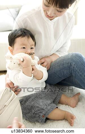 Mother and baby boy sitting on floor View Large Photo Image Stock Image - Mother and baby boy sitting on floor. Fotosearch