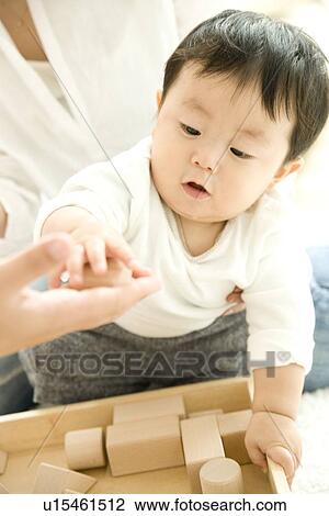 Mother and baby playing in living room View Large Photo Image Stock Image - Mother and baby playing in living room. Fotosearch