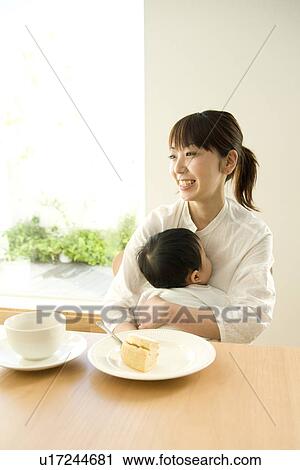 Mother and baby sitting at table View Large Photo Image Stock Image - Mother and baby sitting at table. Fotosearch