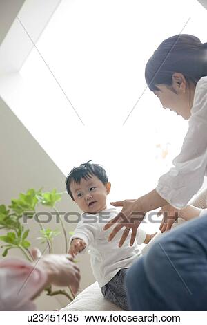 Stock Photography - Mother and father reaching for baby son. Fotosearch