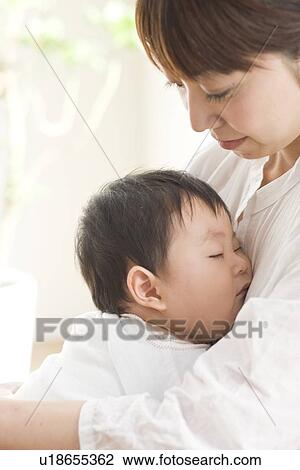 Stock Image - Mother and sleeping baby hugging. Fotosearch