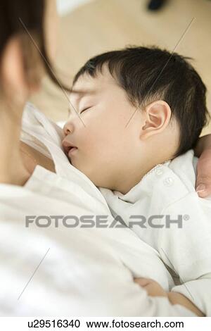 Stock Image - Mother and sleeping baby hugging. Fotosearch