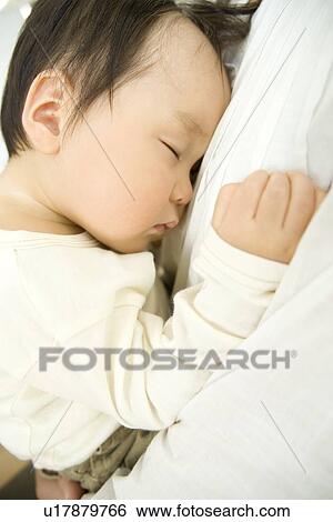 Stock Photograph - Mother and sleeping baby hugging. Fotosearch