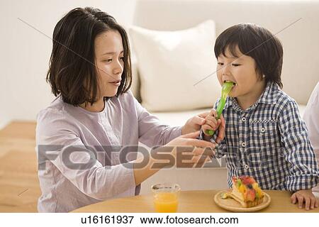 Mother and son eating cake View Large Photo Image Stock Photo - Mother and son eating cake. Fotosearch