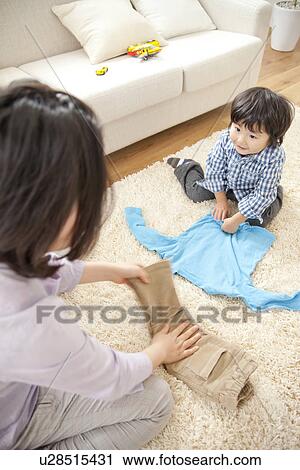 Mother and son folding clothes View Large Photo Image Stock Image - Mother and son folding clothes. Fotosearch