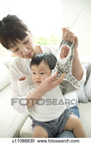 Mother dressing baby son View Large Photo Image Stock Image - Mother dressing baby son. Fotosearch