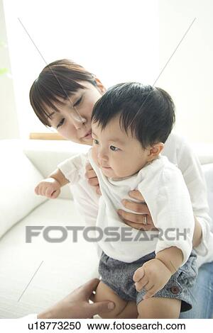Stock Image - Mother holding baby son. Fotosearch