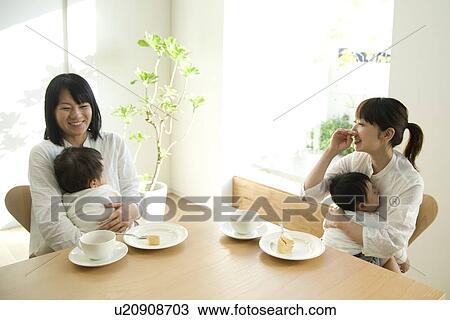Stock Image - Mothers and babies sitting at table. Fotosearch