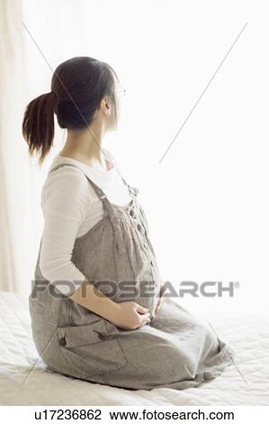 Stock Image - Pregnant Woman Sitting By Window. Fotosearch