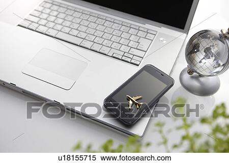 Stock Photography - Smart Phone and Miniature Airplane on Laptop. Fotosearch