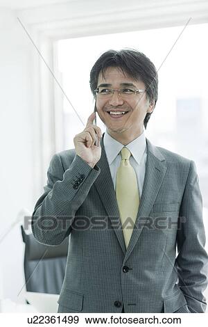 Stock Photo - Smiling Businessman Speaking over Mobile Phone. Fotosearch