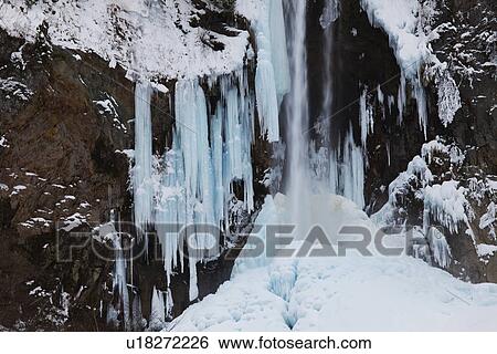 Snowcapped cliff and freezing waterfall View Large Photo Image Stock Photograph - Snowcapped cliff and freezing waterfall. Fotosearch