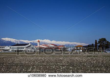 Stock Image - Snowcapped mountain chain behind rural landscape. Fotosearch