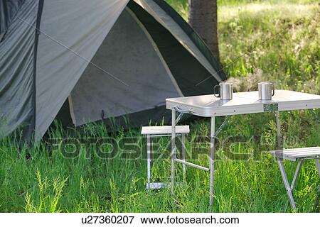 Stock Photo - Tent and Two Steaming Mugs On Campsite, Early Morning. Fotosearch
