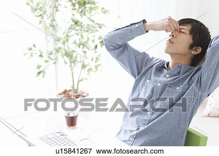 Stock Photo - Tired Young Man Rubbing His Eyes. Fotosearch