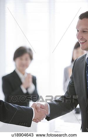 Stock Image - Two Businessmen Shaking Hands. Fotosearch