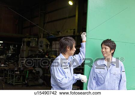 Stock Image - Two Colleagues Talking to Each Other. Fotosearch