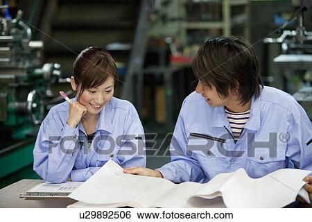 Stock Photograph - Two Factory Workers Reading Documents. Fotosearch